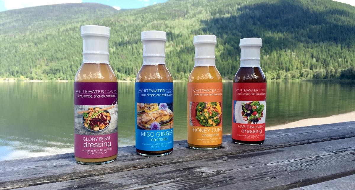 WhiteWater Cooks sauce bottles on a dock with mountain lake
